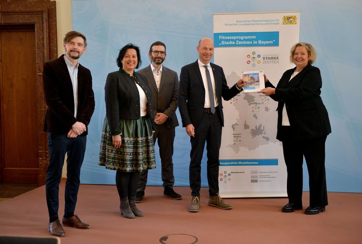 Ministerialdirektorin Dr. Ulrike Wolf überreicht dem Team aus Kempten das Handbuch.